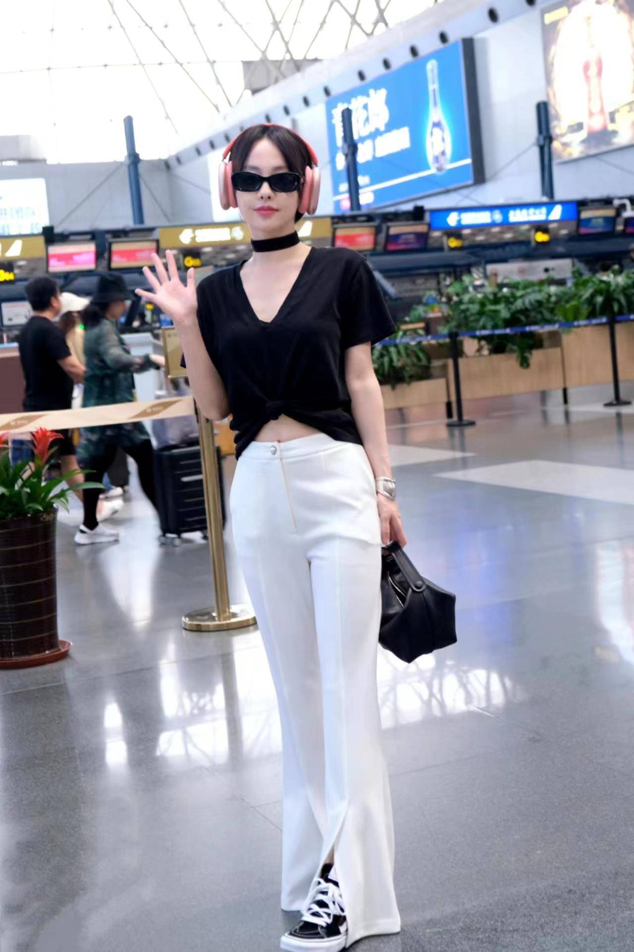 张嘉倪现身机场,身穿黑色裸上衣和白色裤子,简单,时尚,还显得更高!