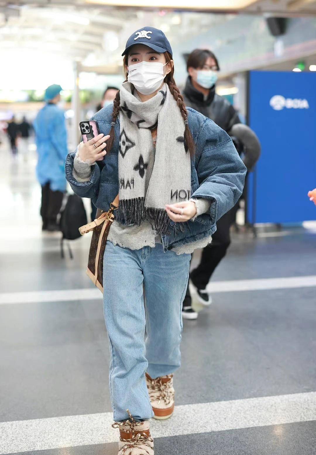 水洗蓝色牛仔裤与滑雪靴的搭配独特又温暖.