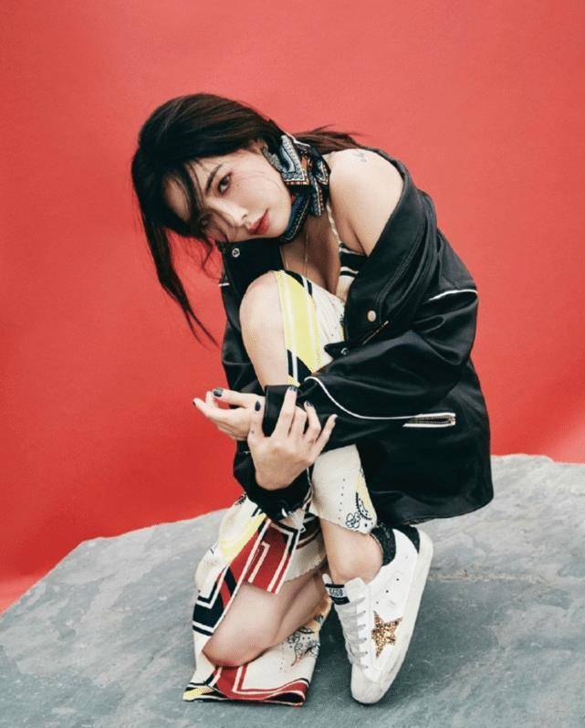 照片中泫雅扎着高高的马尾辫,身穿棕色毛呢外套内搭白色上衣,下身搭配