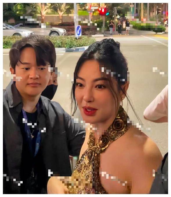 张雨绮身着一身珠光宝气的金色亮片长裙,打扮华丽,但也因为年龄发福而