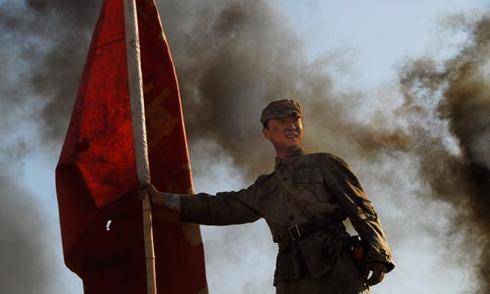 部队稍一停他就把红旗插起来;突击队一前进,他拔起旗来又往前冲