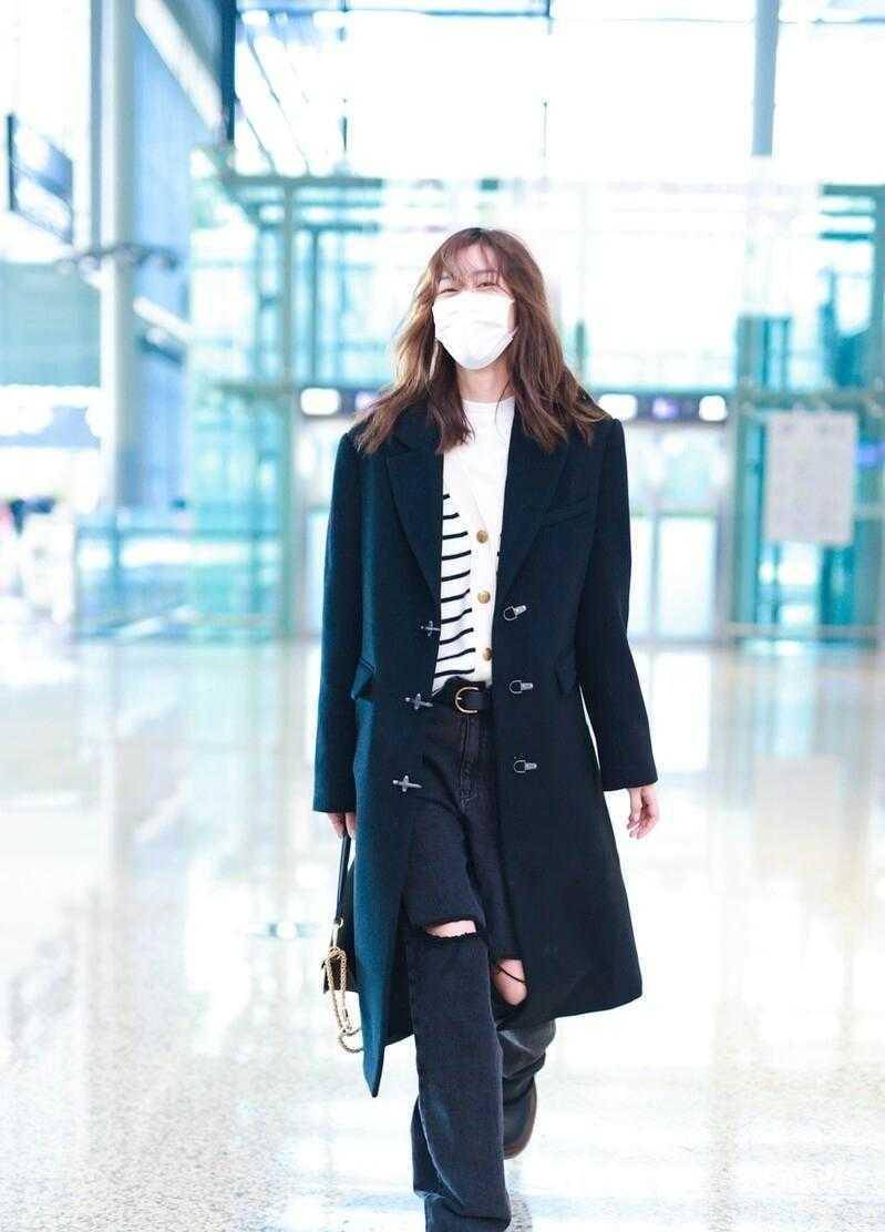 刘雯在上半身穿了一款非常经典的黑色大衣,在秋冬季节穿搭中,这种经典