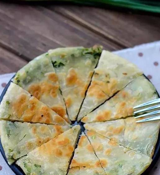 2,将面饼按图中所示方法卷成长条状,再向内卷成蜗牛状.