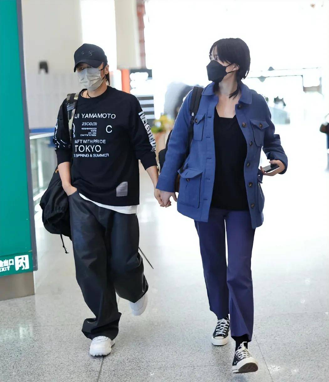 在某次机场照中,王菲身穿蓝色工装外套搭配黑色t恤和蓝色直筒裤,脚踩