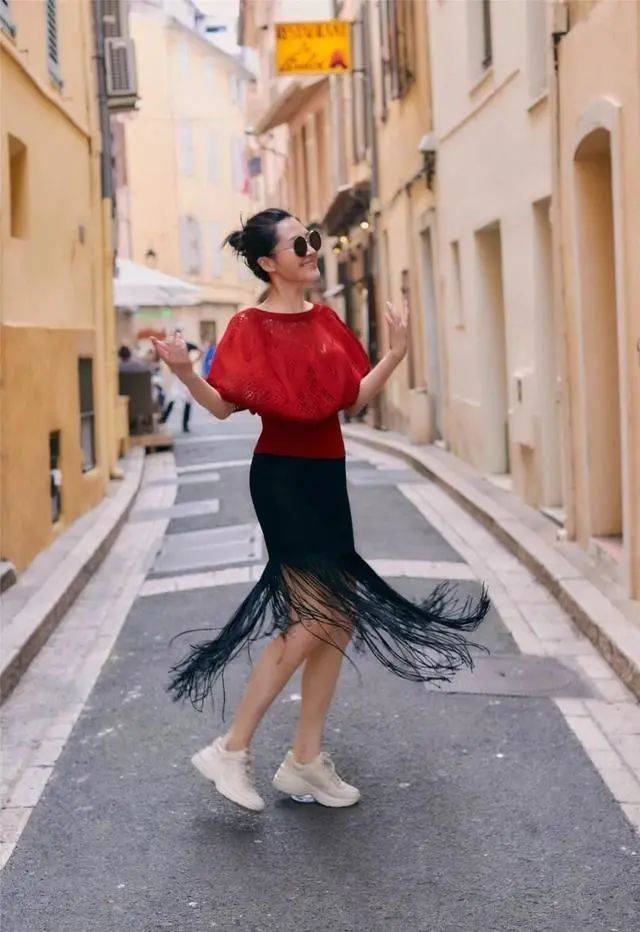 原创55岁许晴又去国外旅游穿红色风衣皮裤短发时髦洋气又减龄