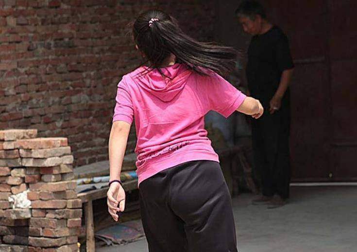 烈日下,一位少女拖着一条腿艰难地行走着,从屋门走到院门都出了一身汗