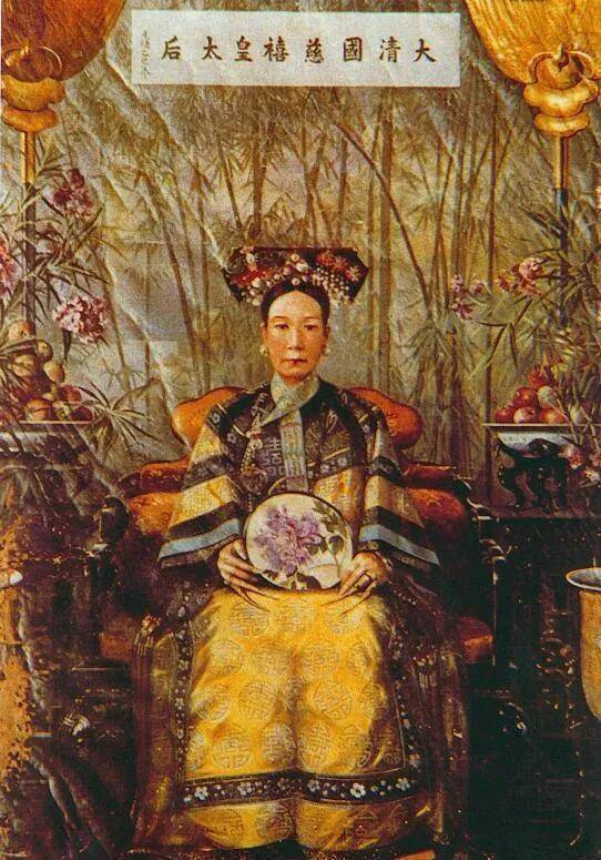 慈禧身穿金丝礼服,外罩绣花串珠褂,颈部有朝珠三串,手执玉莲花一枝,足