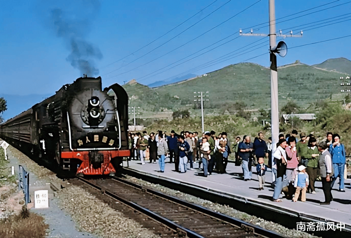 画面里,一列绿皮旧式列车正驶入站台