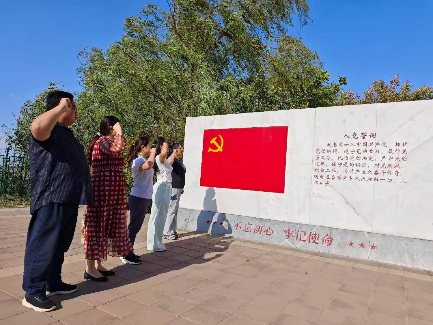 活动中,党员教师们来到入党誓词墙前,面对鲜红的党旗和庄严的入党誓词