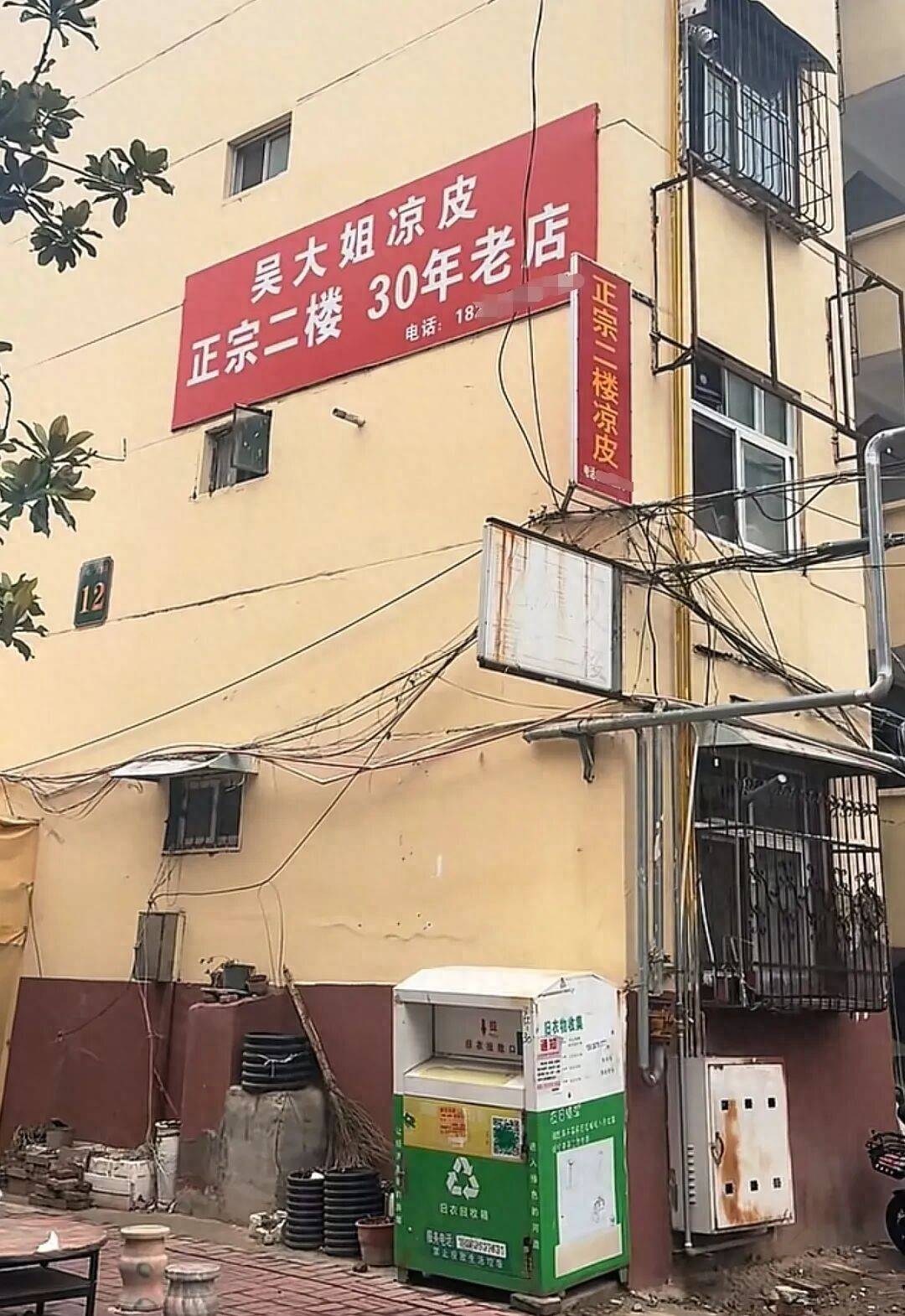 视频截图网友拍摄的视频显示一居民楼外墙张贴了一家餐饮店的招牌
