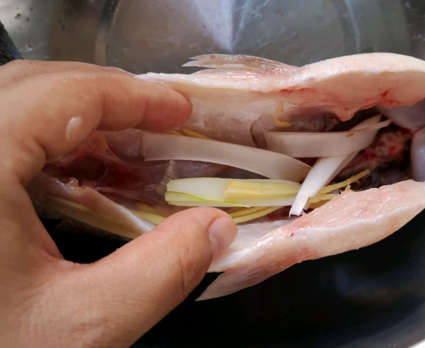 第一步:把鲈鱼洗净切花刀,倒入适量的料酒,蚝油和白胡椒粉加盐搅拌