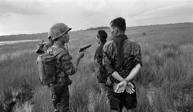 越南南部某平原的一片杂草丛生的沼泽中,一名全副武装的越南士兵正在