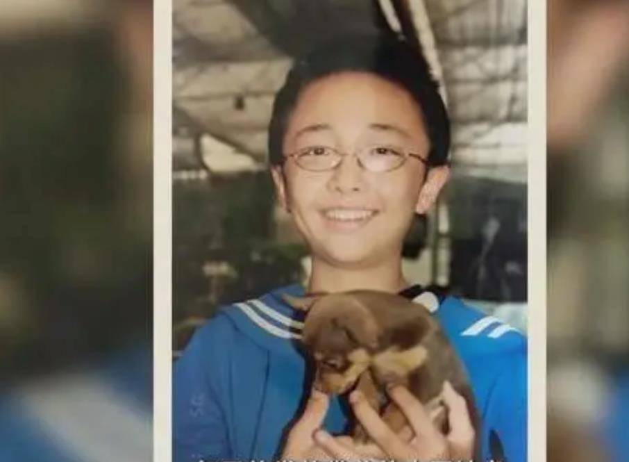 这是童年的小狮和辛巴.只见一位戴着眼镜的小男孩抱着一只小狗.