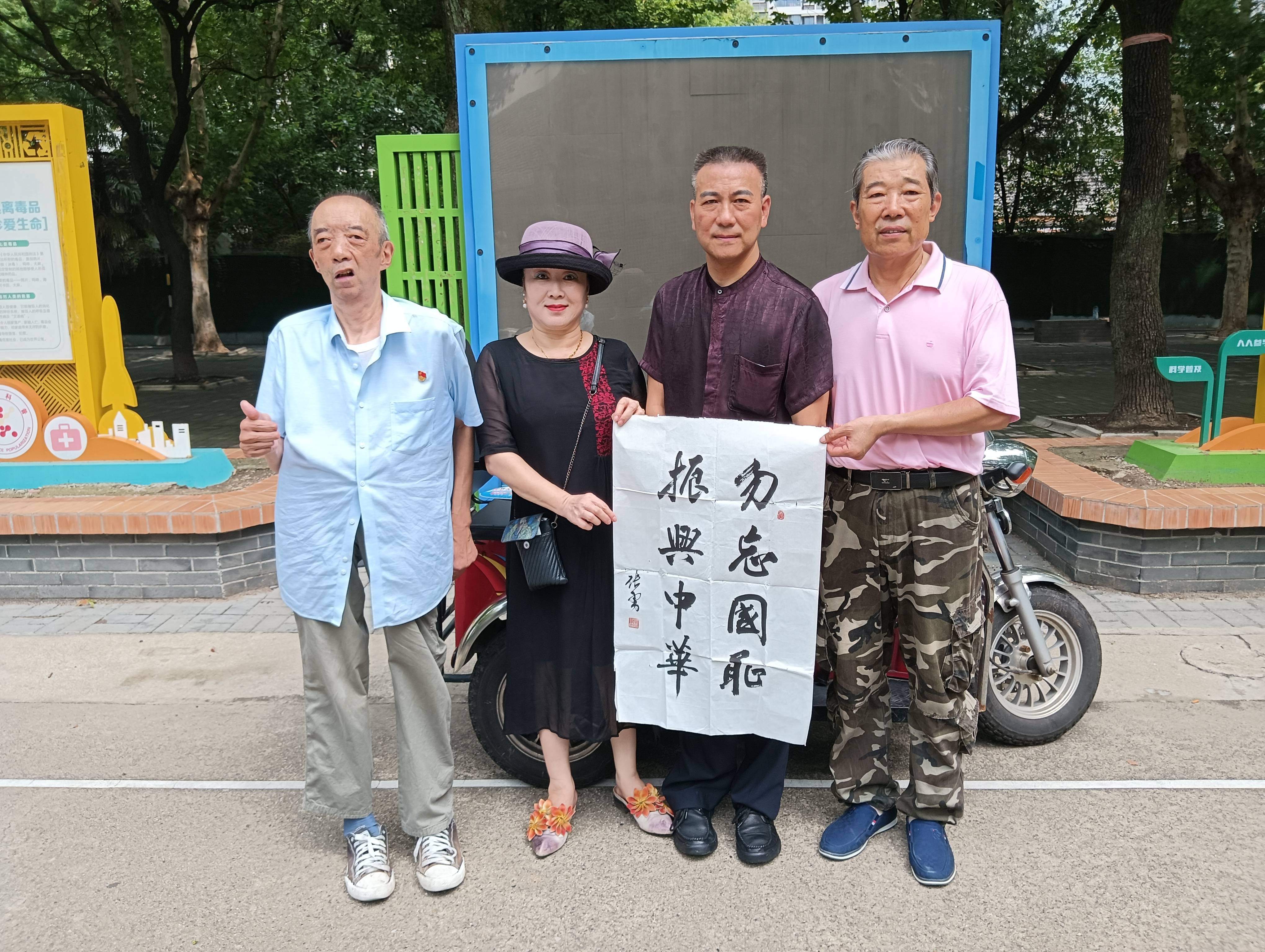 陈斌(左1)王珏(左2)张勇(左3)王长明(右1),手持张勇书写的书法作品