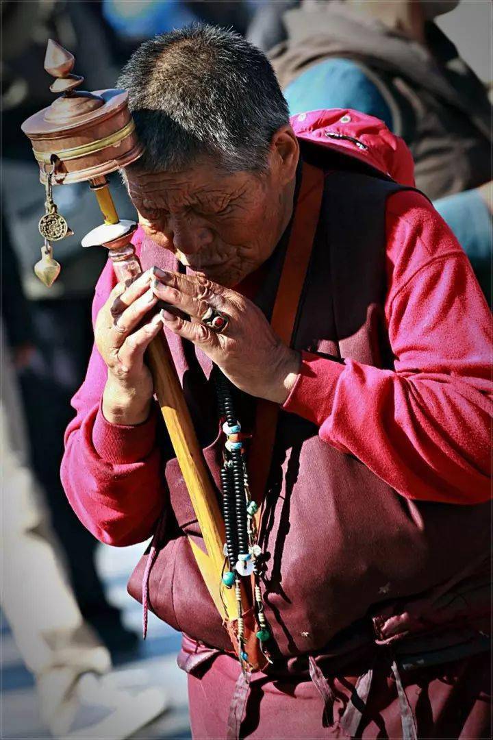 手拿转经筒的藏民图片图片