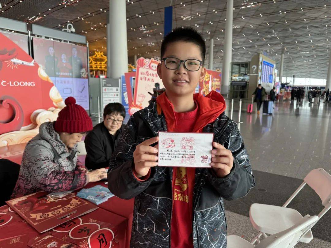 小旅客艾祺轩体验定制明信片活动/记者拍摄旅客郭郛老先生体验"写