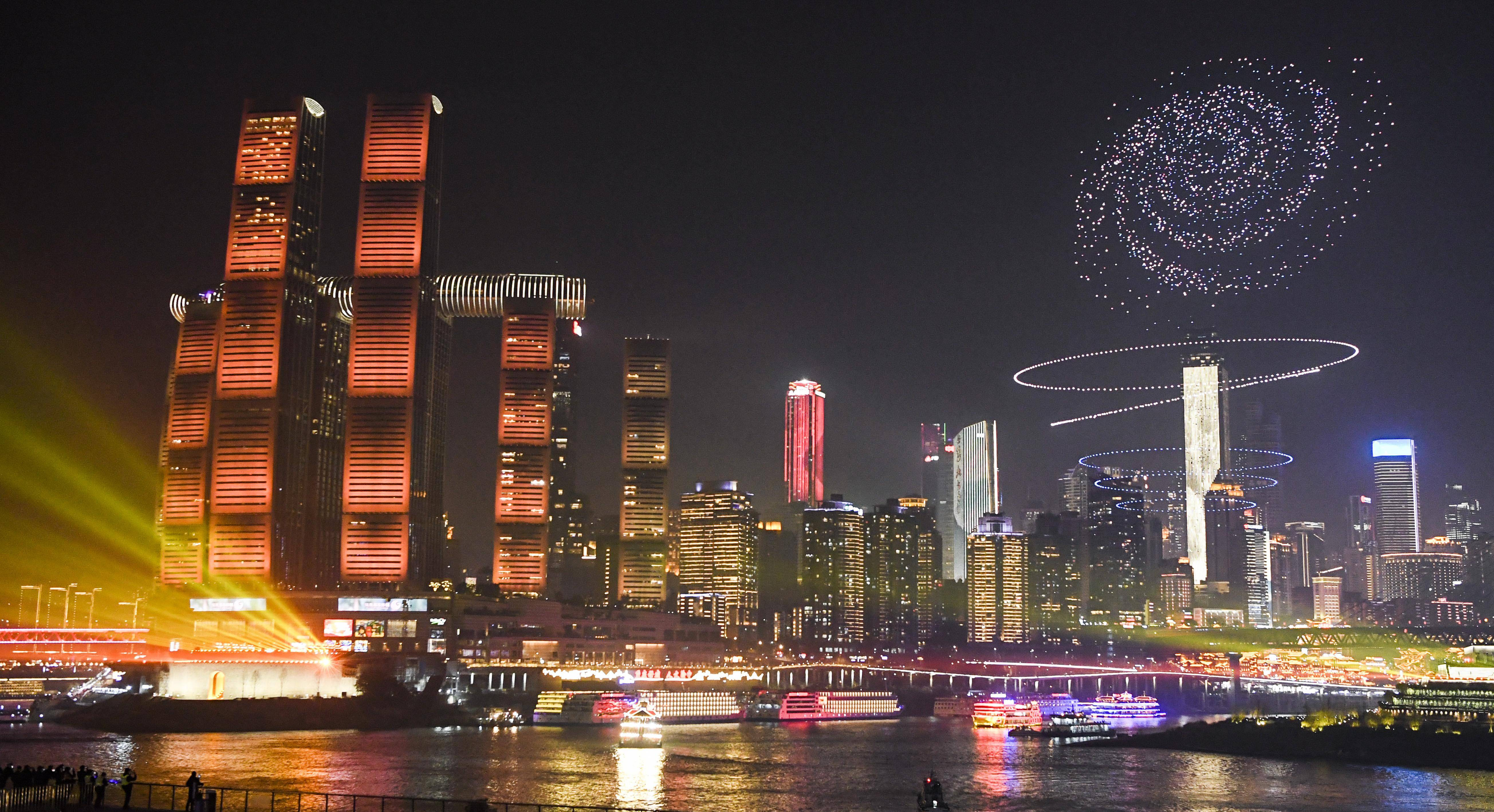 这是2月9日晚拍摄的2024重庆两江四岸夜景灯饰联动展演多媒体灯光秀