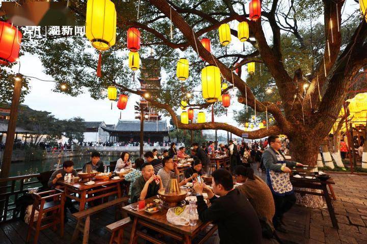 2月13日晚,浙江嘉兴乌镇景区在街巷大摆长街宴,游客边吃着美食,边欣赏