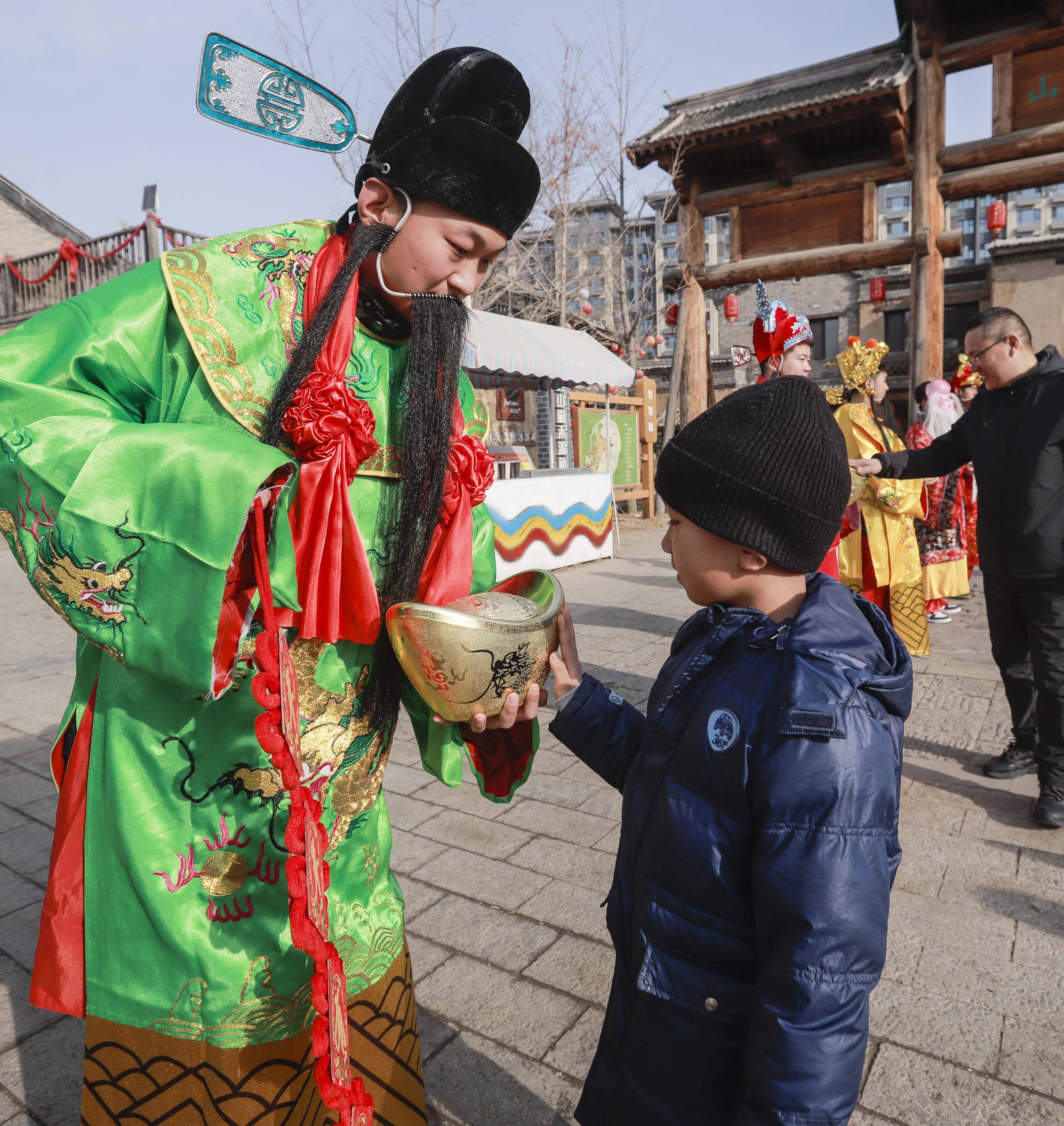 2月14日,河北省遵化市兴旺寨镇尚禾源庙会"五路神仙"向游客送祝福.