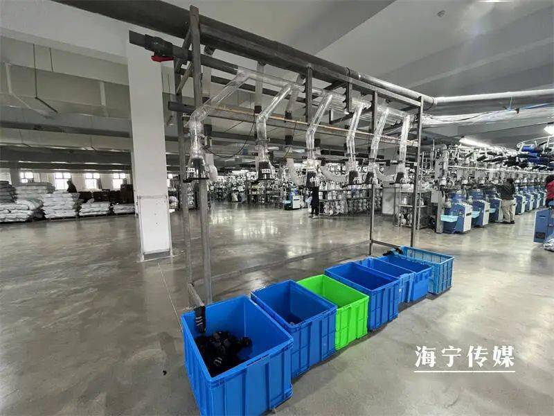 工人们来回穿梭在全自动化织袜机前,仔细查看机器运作状态……只见