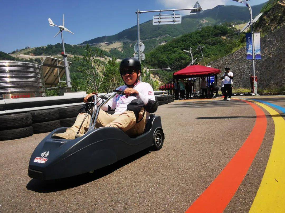 人们乘着"高山滑车",以无动力自由滑行的方式,感受与雪季不一样的风驰