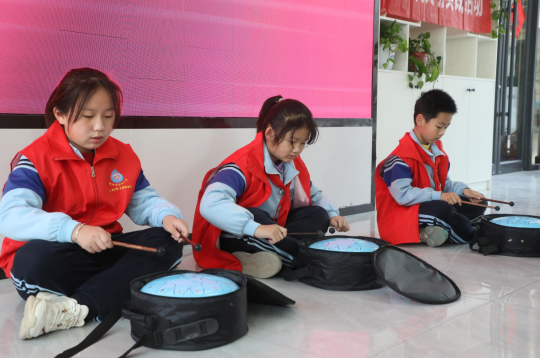上午九点多,穿着统一校服,佩戴鲜艳红领巾的"红马甲"少先队志愿者们
