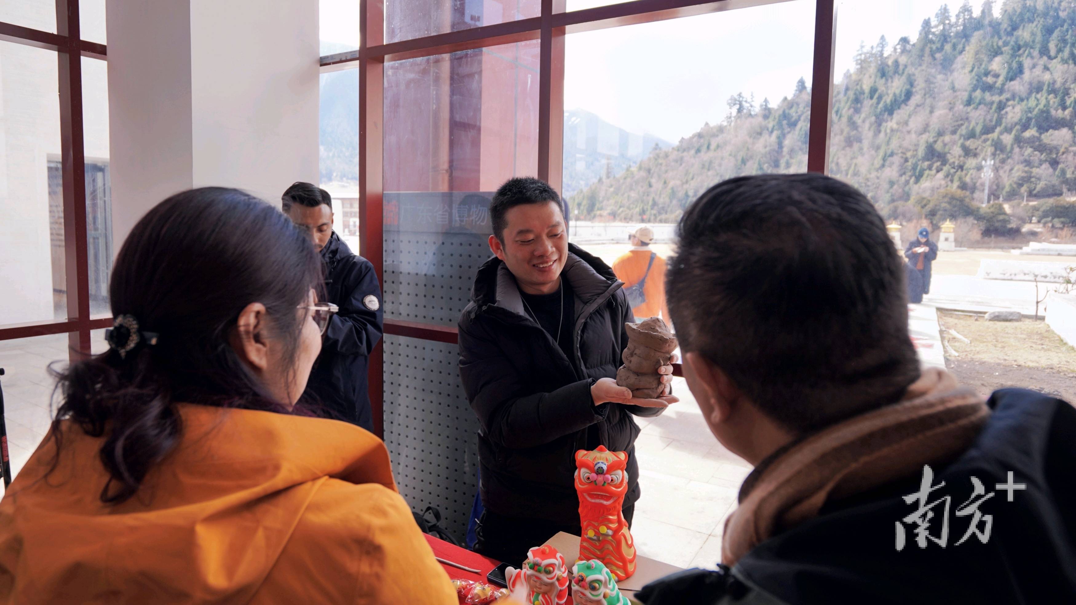 在佛山黎家狮第六代传人周嘉欣的摊位前,制作精细,五颜六色的狮头引来