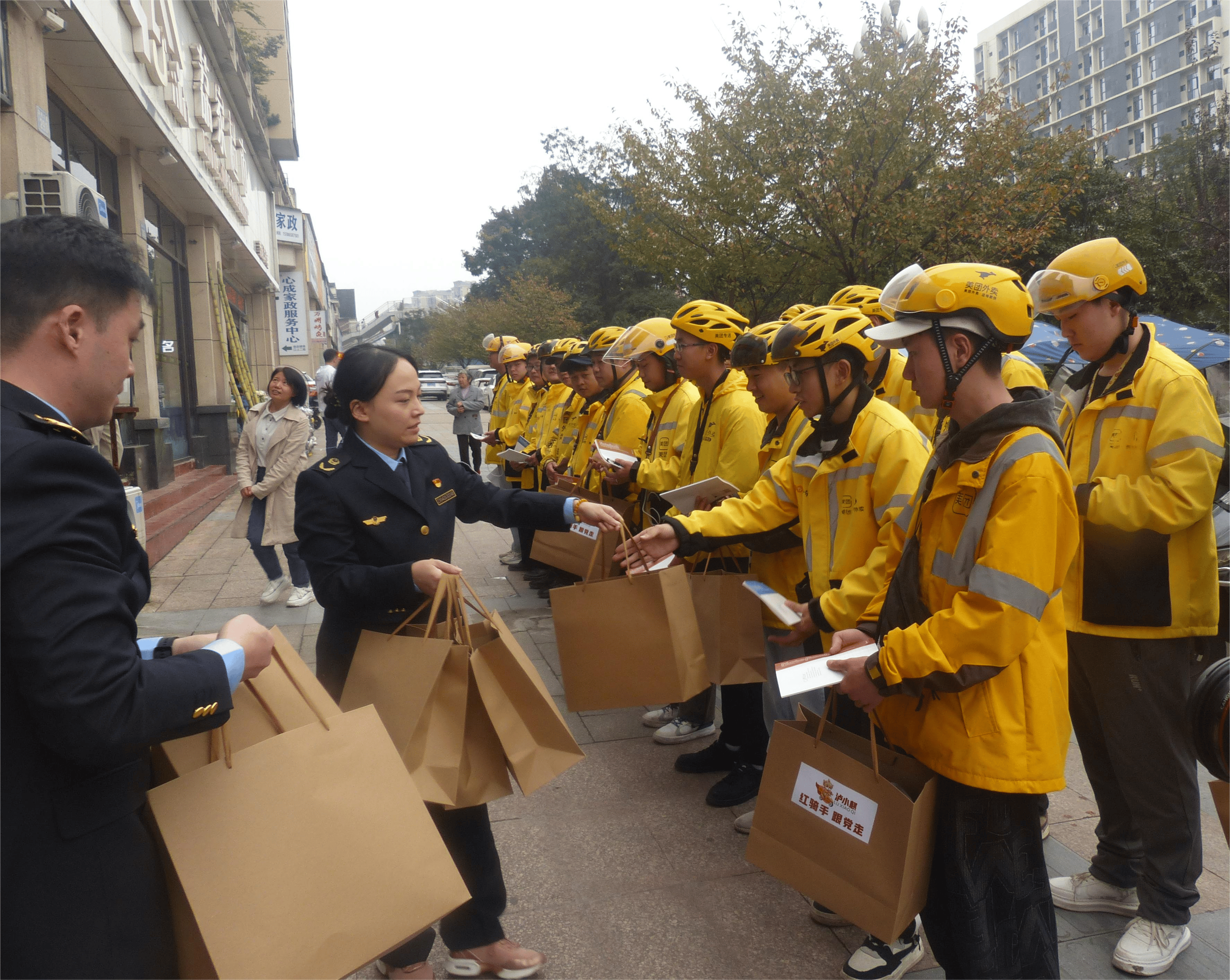 泸州市市场监管局机关党员正在向外卖骑手们发放慰问品在助力企业贷款