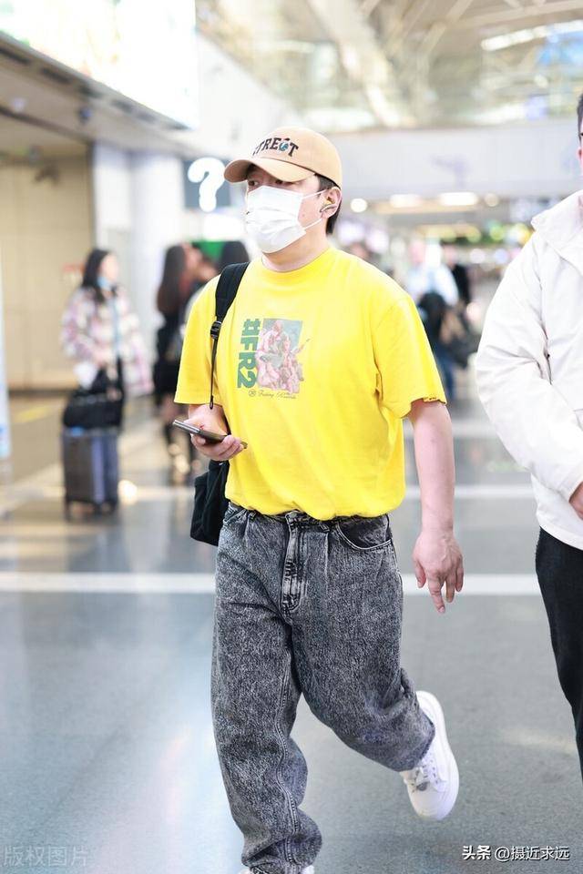 49岁演员黄渤现身北京机场黄色t恤搭配牛仔裤休闲亮眼