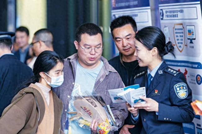 4月12日,金华市区江北商圈里,金华市婺城区公安民警向市民讲解国家