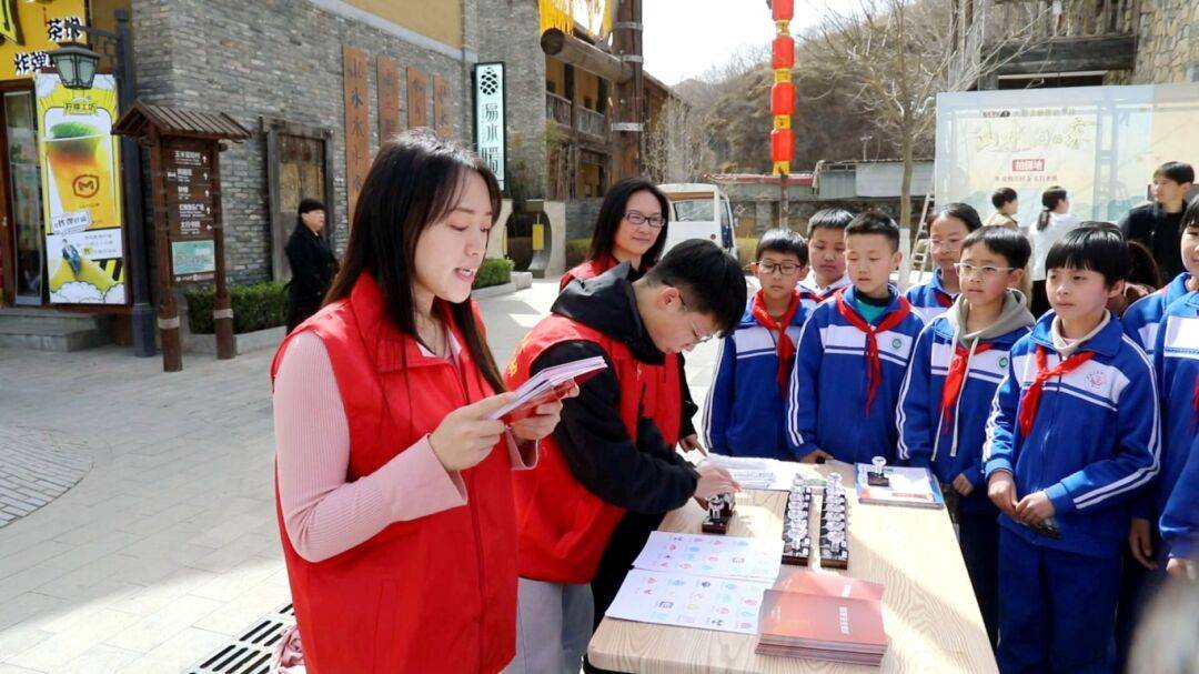 县委办工作人员张艺蓝正给来自易县大龙华中心小学五年级的同学们提问