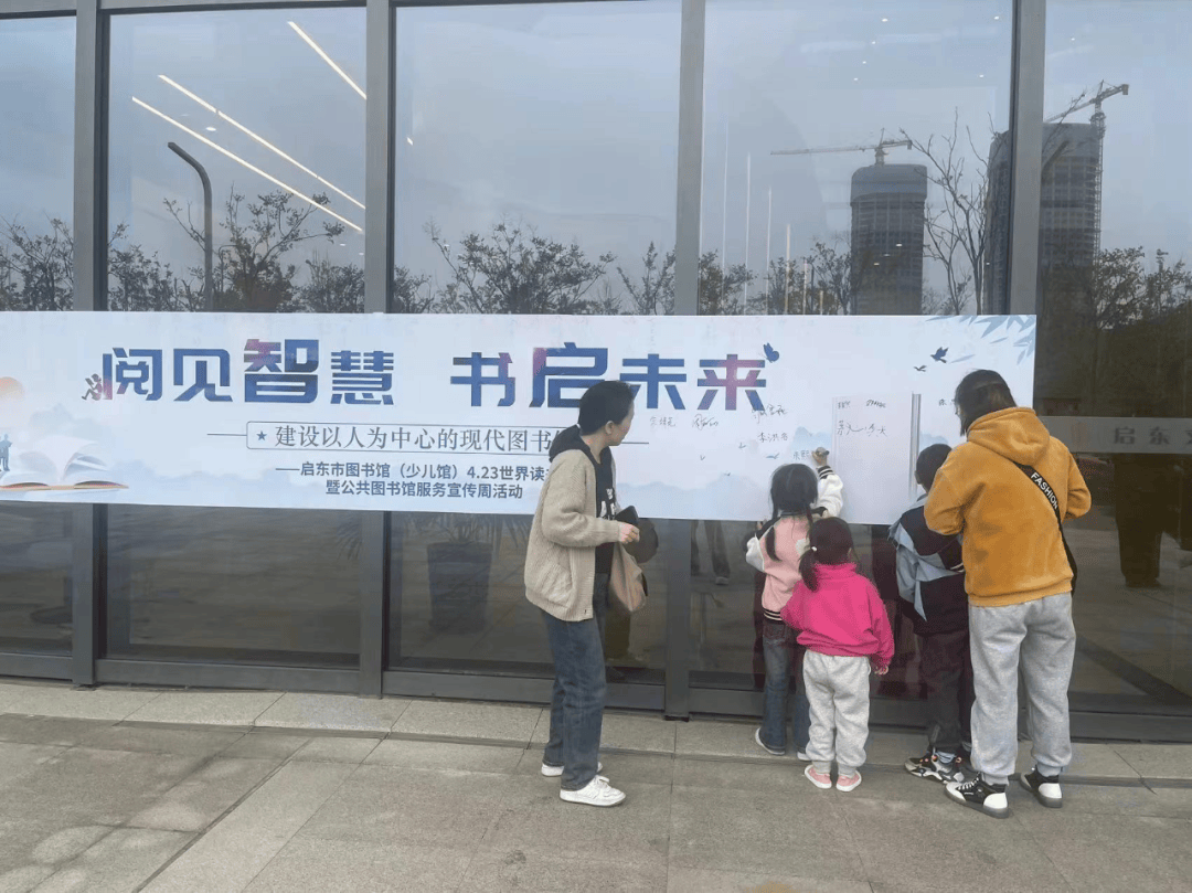 23世界读书日的横幅上签名,并与横幅合影留念.