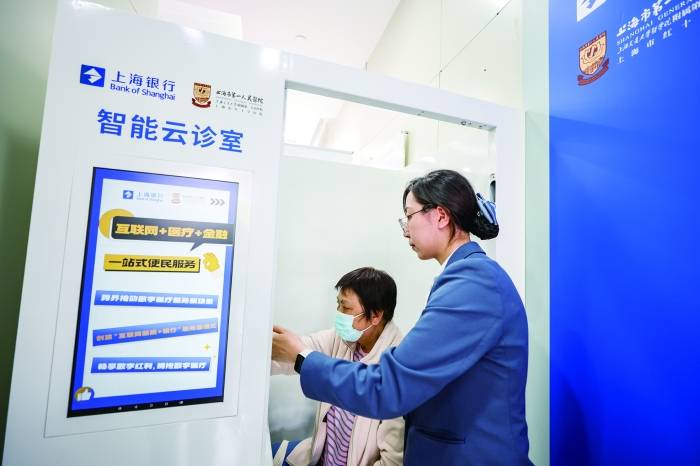 姜阿姨在志愿者帮助下体验智能云诊室 图源:上海市银行同业公会