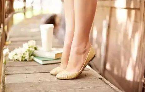 双手扶着桌边以辅助身体平衡,双腿自然地站立并排,提起脚跟,保持二