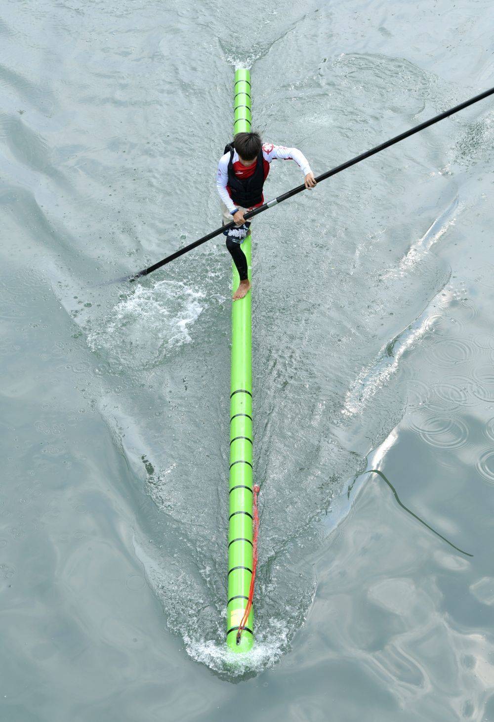 喜爱水上运动的市民们脚踩"竹竿"在水上漂行,让非遗"独竹漂"这一民间