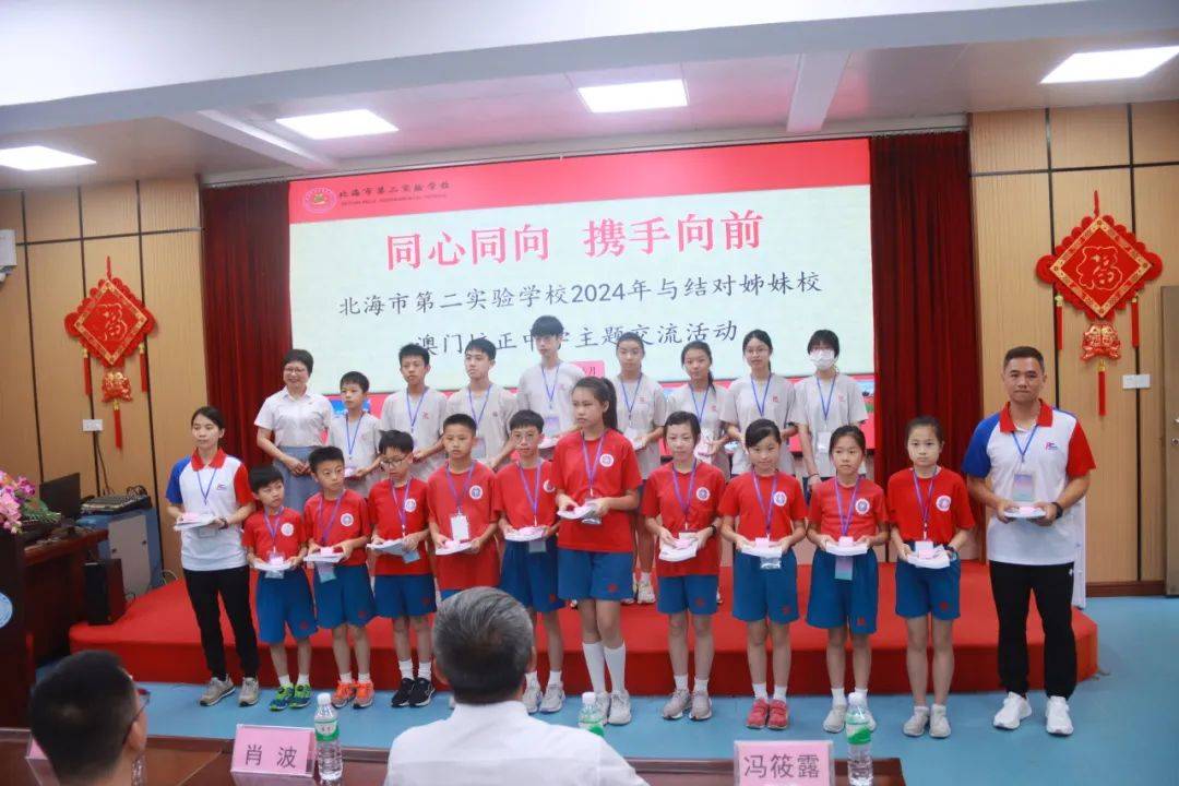 副校长给澳门培正中学的师生赠送校徽及学校组织编写的每周一诗读本