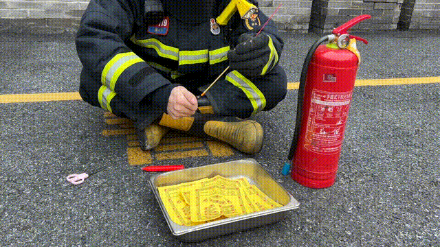 消防员点燃立香,当其充分燃烧后,将前端烧红香灰段剪下放在纸钱上